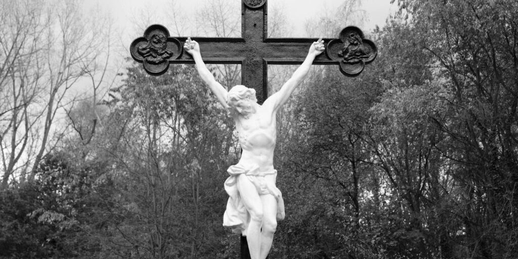 photo by g r mottez a black and white photo of a statue of jesus on a cross